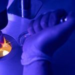 Investigador-de-laboratorio-genético-agregando-material-de-biopsia-al-tubo-de-ensayo